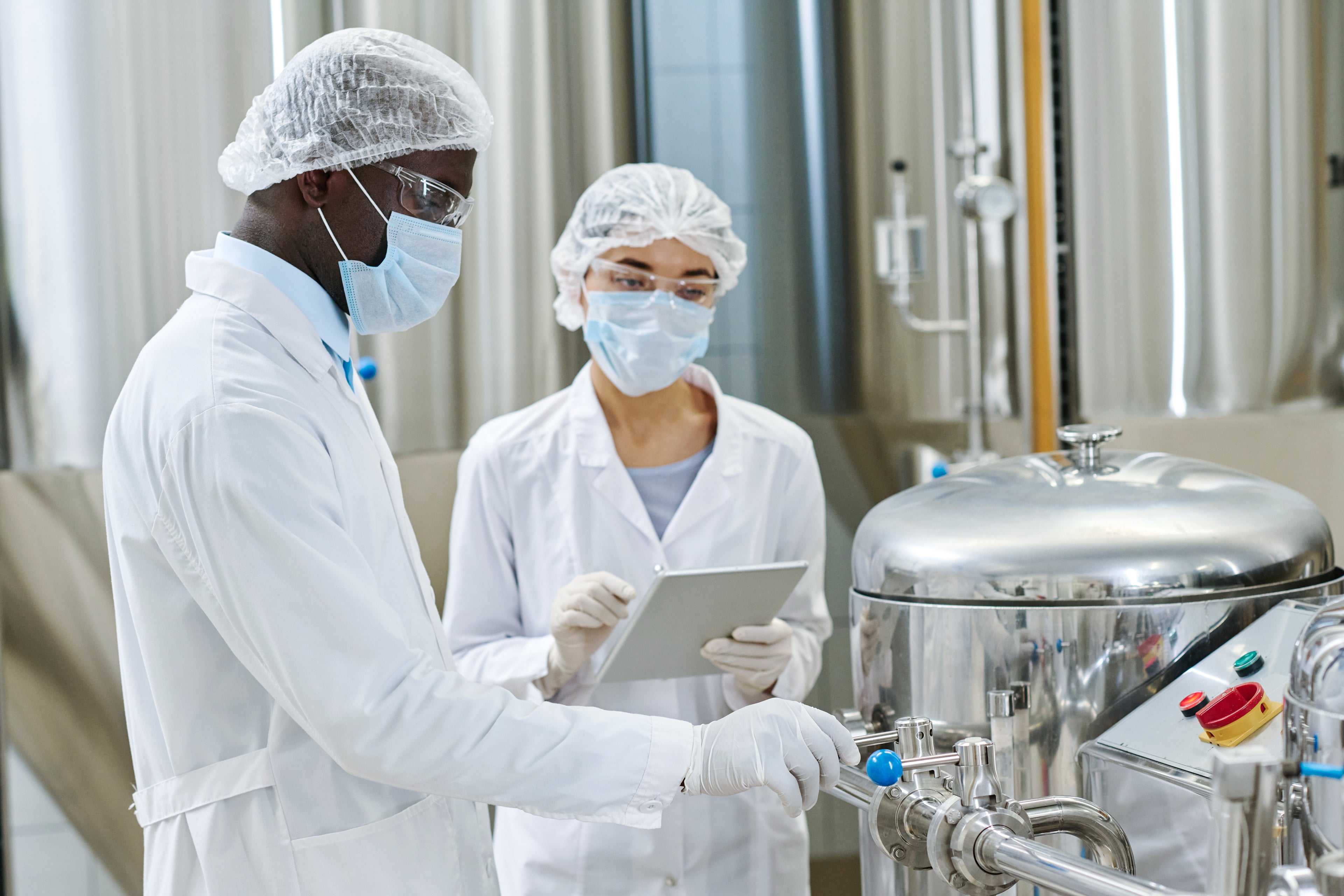 Chemical manufacturing facility with technicians monitoring industrial processing equipment for quality control and safe production.