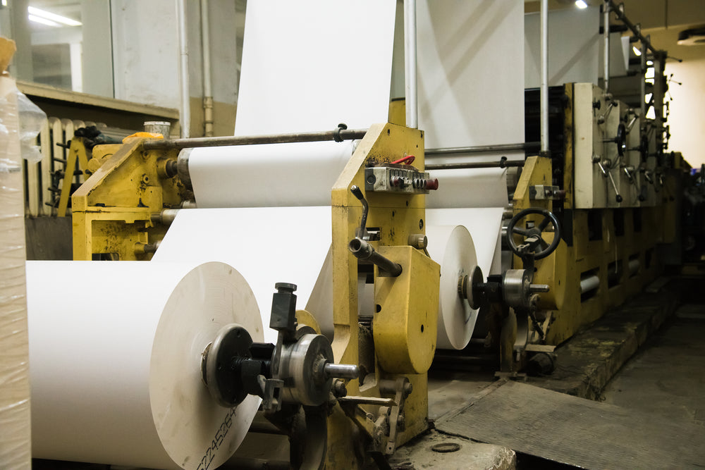 Industrial paper manufacturing machine producing paper rolls for high-volume paper converting and production.